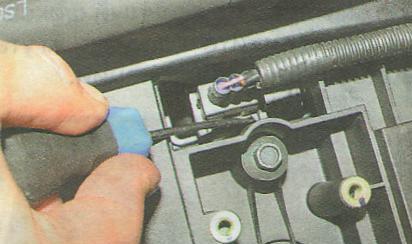 Нажмите отверткой на фиксатор жгута