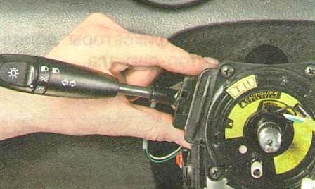 Сожмите фиксаторы левого подрулевого переключателя