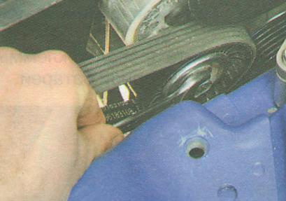 Поверните по часовой стрелке ось натяжного ролика ремня привода вспомогательных агрегатов