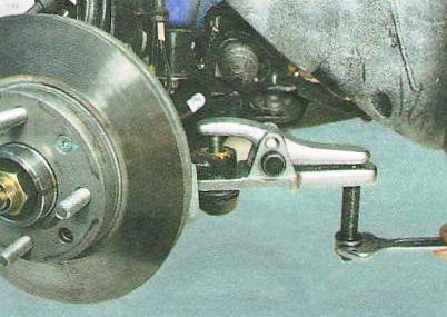 выпрессуйте палец из бобышки рычага поворотного кулака.