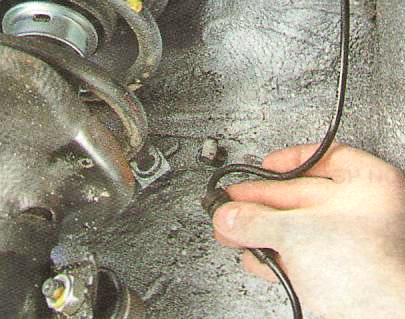 Отсоедините жгут от держателя на кузове