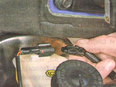 Отсоедините от бачка колодку жгута проводов 