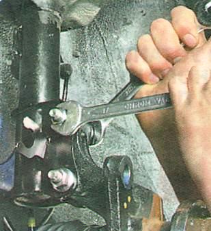 Отверните гайки болтов крепления поворотного кулака к амортизаторной стойке 