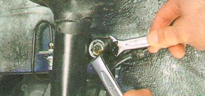 Отверните гайку крепления верхнего шарнира стойки стабилизатора 