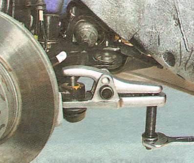 Установите съемник шаровых шарниров и выпрессуйте палец из рычага 