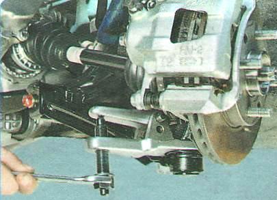 Установите съемник шаровых шарниров и выпрессуйте палец из кулака