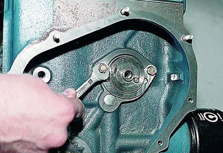 Ключом «на 10» отворачиваем два болта крепления упорного фланца валика