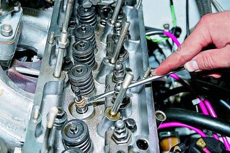 Отверткой поддеваем и снимаем маслоотражательный колпачок с направляющей втулки