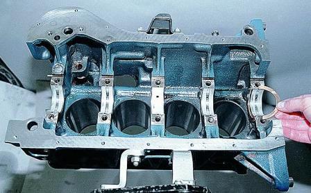 Из проточек постели пятого коренного подшипника вынимаем два полукольца 