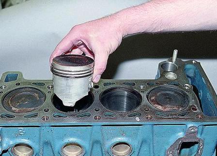 Упираясь деревянной ручкой молотка в шатун, выталкиваем поршень из цилиндра