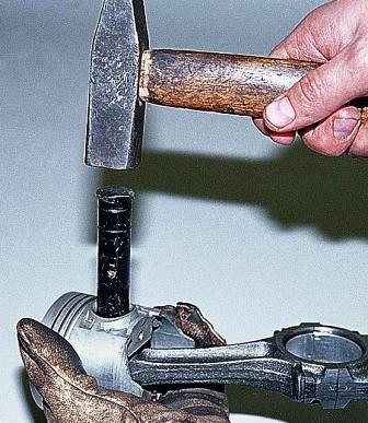 Установив поршень на деревянную оправку с отверстием или удерживая на весу, выбиваем палец