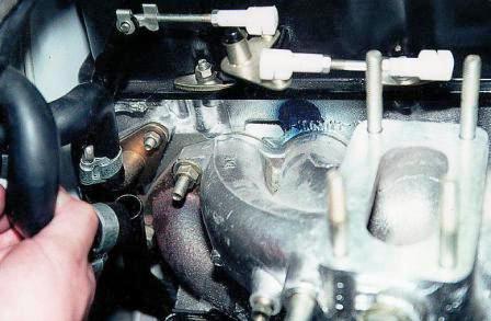 Снимаем с отводящей трубы шланг отвода охлаждающей жидкости 