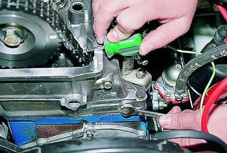 Удерживая отверткой успокоитель цепи, ключом «на 10» отворачиваем два болта его крепления