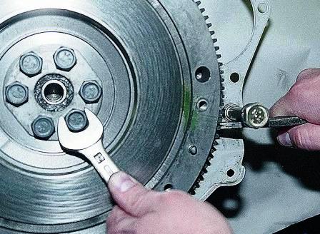 монтажной лопаткой или большой отверткой удерживаем маховик от проворачивания