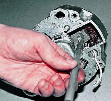 Выколоткой из мягкого металла выбиваем ротор из задней крышки