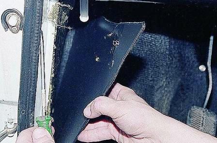 Поддев отверткой, снимаем левую обивку боковины. 