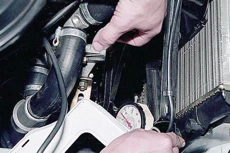 между шкивами генератора и насоса охлаждающей жидкости или насоса и коленчатого вала, под усилием 10 кгс. 