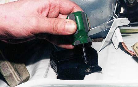 крестообразной отверткой отворачиваем два самореза крепления блока