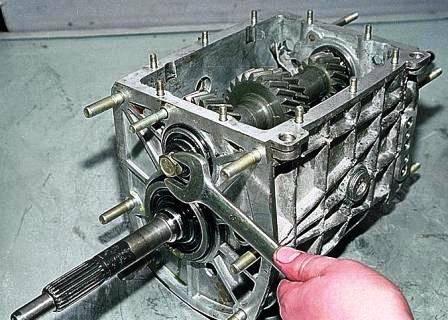 Нажав на муфты, включаем сразу две передачи и ключом «на 19» отворачиваем болт крепления переднего подшипника 