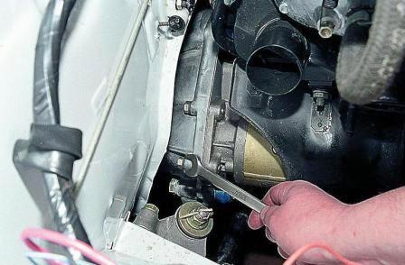 головкой «на 13» с карданным шарниром отворачиваем два верхних болта крепления стартера 