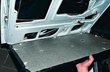 Немного опускаем обивку и снимаем ее с внутренней ручки двери