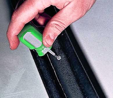 Крестообразной отверткой отворачиваем три самореза крепления накладки