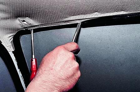 Шлицевой отверткой упираемся во внутреннюю кромку уплотнителя стекла и заправляем ее за отбортовку