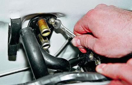 Ключом «на 8» отворачиваем два самореза