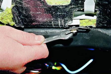 Ключом «на 10» в открывшемся проеме отворачиваем гайку