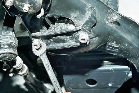 Снизу автомобиля ключом «на 13» отворачиваем две гайки крепления кронштейна амортизатора 