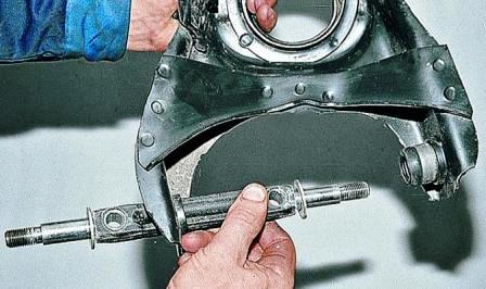 через свободное отверстие в рычаге вставляем ось с шайбами 