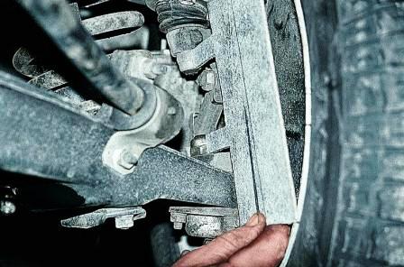 Доворачиваем гайки на пальцах шаровых шарниров так, чтобы их грани стали перпендикулярны продольной плоскости автомобиля, и прикладываем к ним шаблон