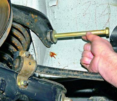 Вынимаем ось верхнего рычага и снимаем рычаг с автомобиля