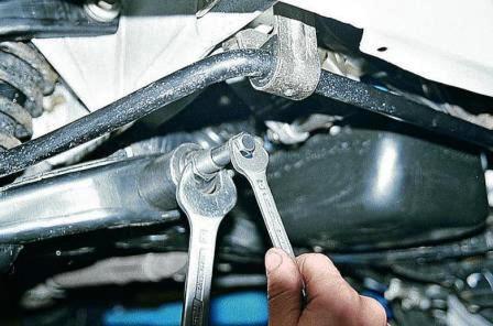 Полый болт наворачиваем на резьбовой конец оси. Затягиваем большую гайку приспособления, давя на рычаг. 