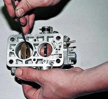 Приоткрыв заслонку, надфилем стачиваем резьбовую часть винтов – на заводе их контрят