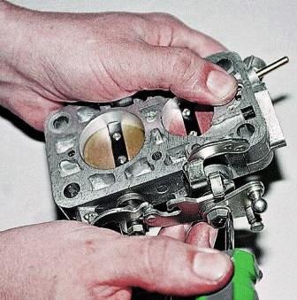 Отверткой отгибаем усик стопорной шайбы гайки оси 