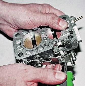 Отверткой отгибаем усик стопорной шайбы гайки оси 