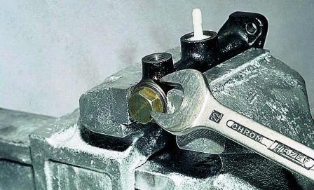 Зажав цилиндр в тисках, ключом «на 22» отворачиваем пробку