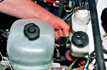 Отстегиваем ремень крепления расширительного бачка 