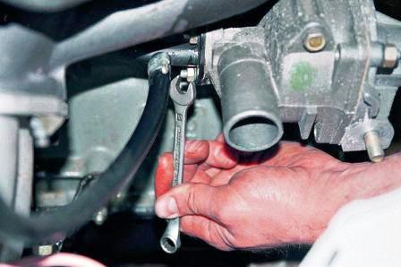  отворачиваем две гайки крепления трубы отвода жидкости от радиатора 