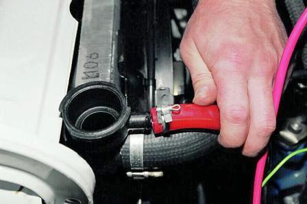 Ослабив хомут, отсоединяем от радиатора шланг расширительного бачка