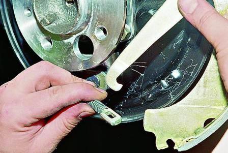 Отсоединяем рычаг привода стояночного тормоза от наконечника троса