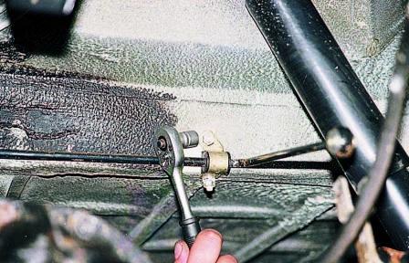 Головкой «на 10» отворачиваем две гайки скобы крепления рычага к кузову