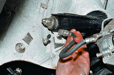 Вынимаем из кронштейна тормозной шланг, а на тормозную трубку надеваем защитный колпачок прокачного штуцера 