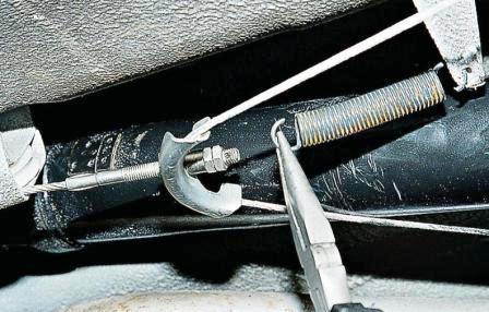 Пассатижами отсоединяем пружину от переднего (короткого) троса