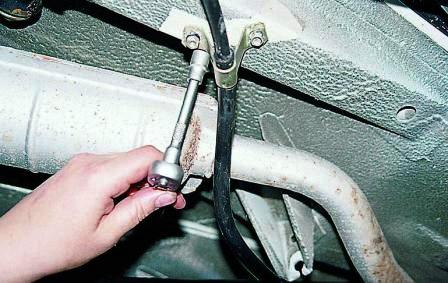 Ключом «на 10» отворачиваем две гайки крепления скобы троса к кузову 