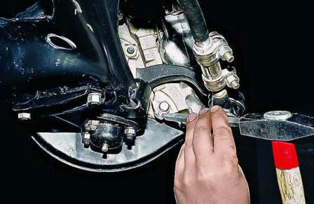 Зубилом отгибаем стопорные пластины двух болтов крепления суппорта