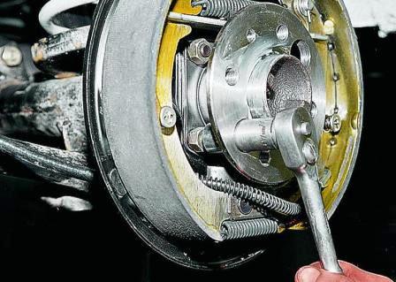 Головкой «на 17» через отверстия во фланце полуоси отворачиваем четыре гайки