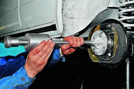 На фланце полуоси закрепляем ударный съемник и выбиваем полуось из балки