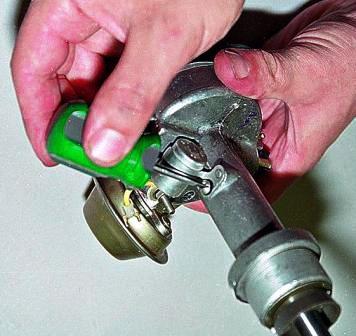 Отверткой отворачиваем винт крепления конденсатора